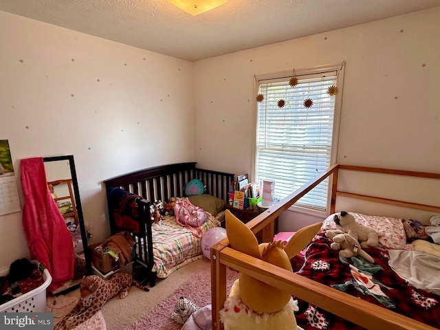 bedroom featuring a textured ceiling and carpet flooring