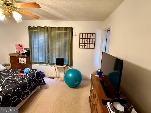 carpeted bedroom with baseboards, a textured ceiling, and a ceiling fan