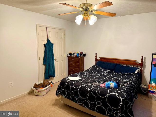 carpeted bedroom featuring a closet, baseboards, a textured ceiling, and ceiling fan