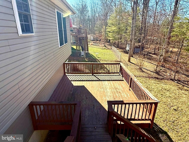 deck featuring stairs and a yard