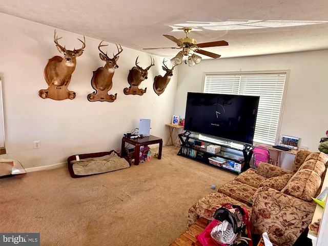 living area with baseboards, carpet floors, a textured ceiling, and a ceiling fan