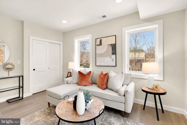 living room with recessed lighting, wood finished floors, visible vents, and baseboards