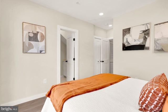 bedroom featuring recessed lighting, wood finished floors, baseboards, and a closet