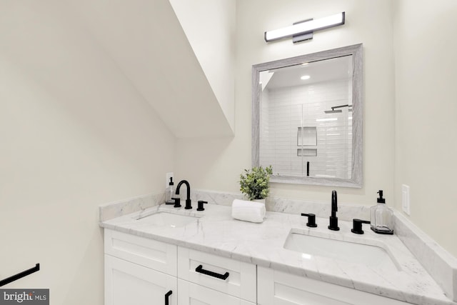 bathroom featuring a sink, a stall shower, and double vanity