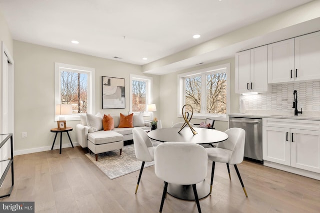 dining space with light wood-style flooring, recessed lighting, and baseboards