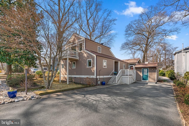 view of front of house featuring a balcony and an outdoor structure