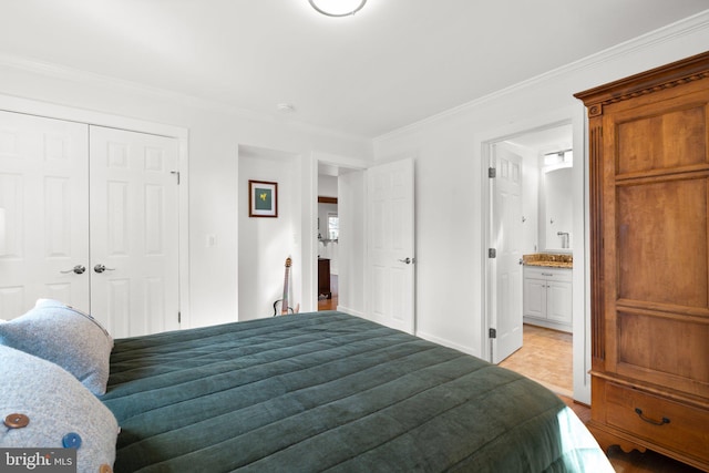 bedroom with ensuite bath, baseboards, a closet, and ornamental molding