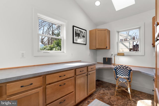 kitchen with vaulted ceiling with skylight and built in study area