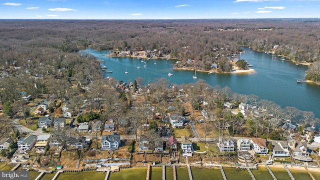 drone / aerial view with a forest view and a water view