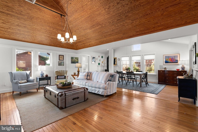 living area featuring baseboards, high vaulted ceiling, hardwood / wood-style flooring, wood ceiling, and a notable chandelier