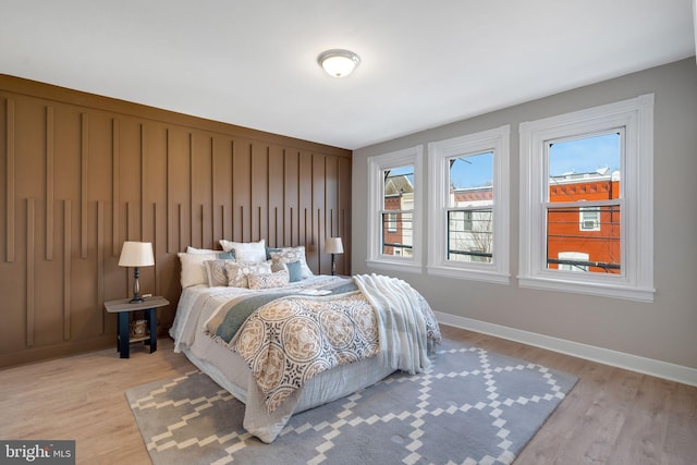 bedroom with light wood-type flooring and baseboards