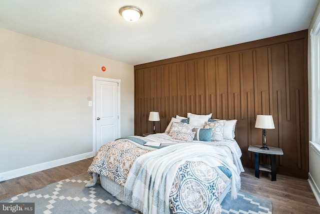 bedroom with baseboards and wood finished floors