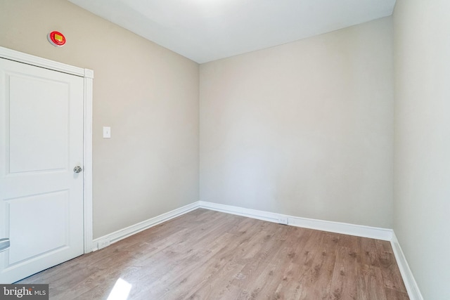 empty room featuring baseboards and light wood finished floors