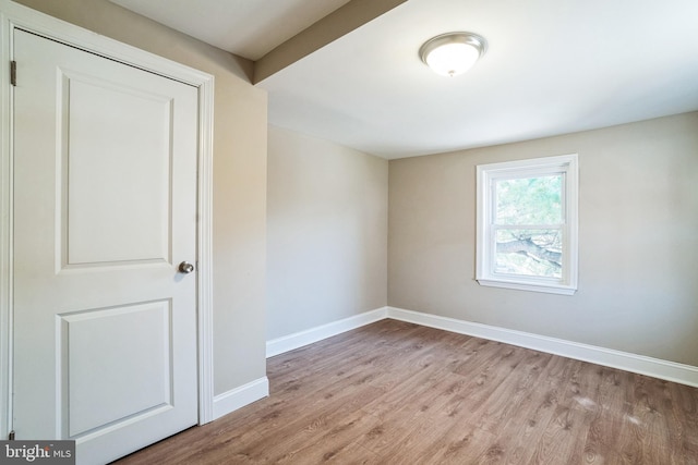 empty room with baseboards and wood finished floors