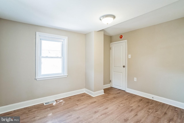 unfurnished room with light wood-style floors, baseboards, and visible vents