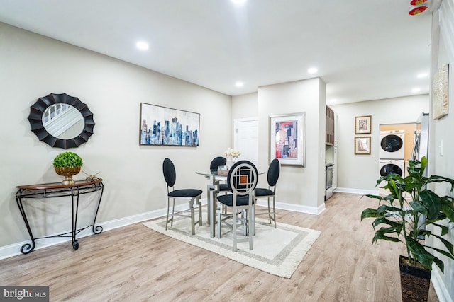 dining room featuring stacked washer / dryer, recessed lighting, light wood-type flooring, and baseboards