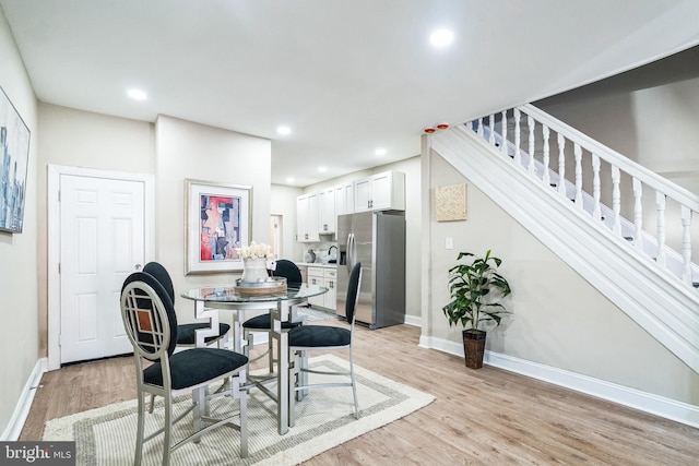 dining room featuring stairs, recessed lighting, baseboards, and light wood finished floors