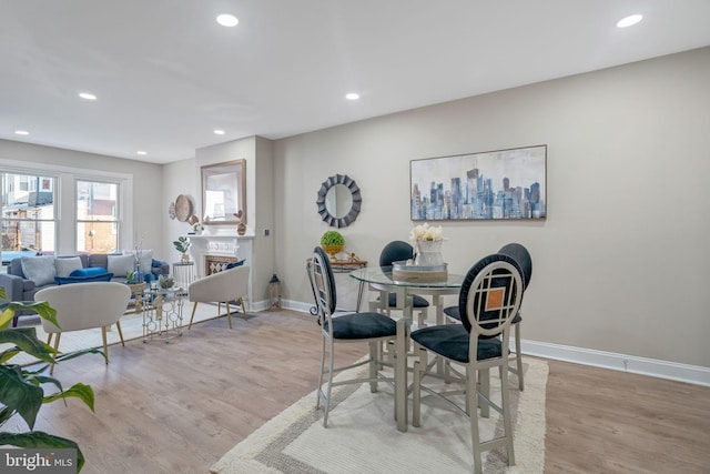 dining room with recessed lighting, light wood-type flooring, and baseboards