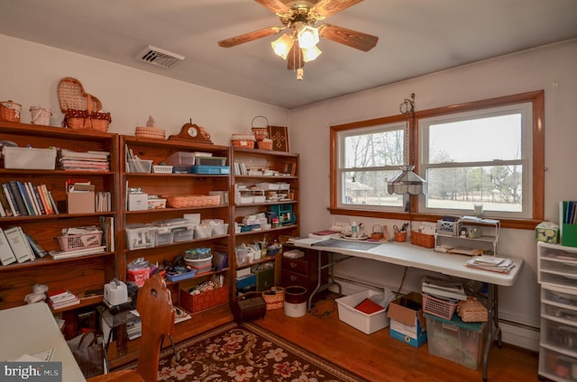 office space with visible vents, a ceiling fan, and wood finished floors