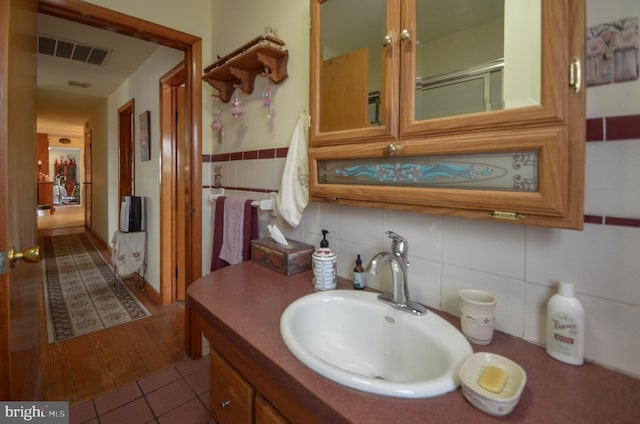 bathroom featuring visible vents, tile walls, vanity, and tile patterned flooring