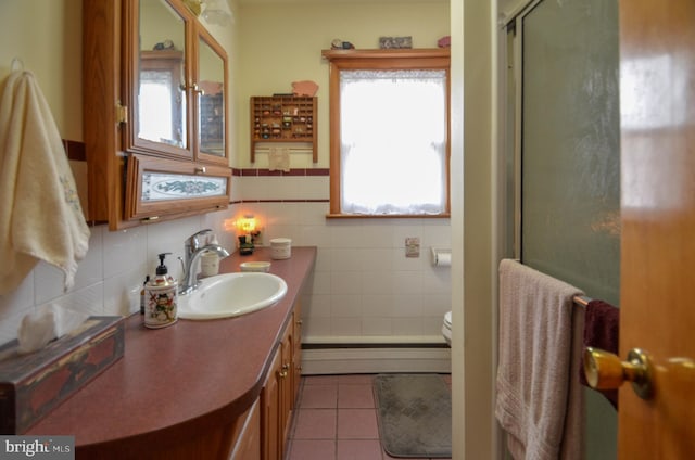 bathroom featuring tile patterned floors, toilet, a shower with door, a baseboard heating unit, and vanity