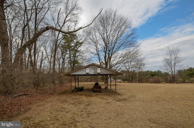 view of yard with a carport and dirt driveway