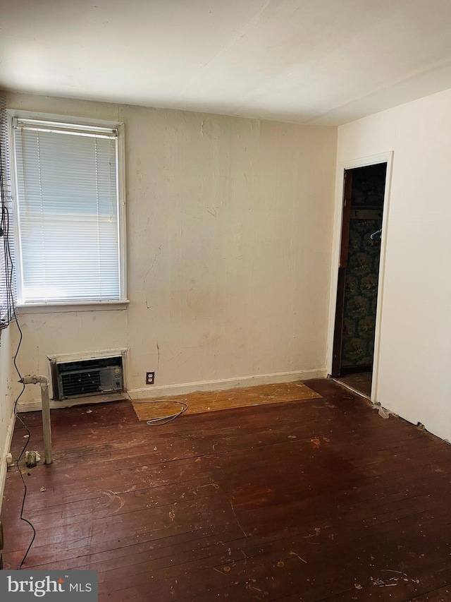 spare room featuring a wall mounted AC and wood finished floors