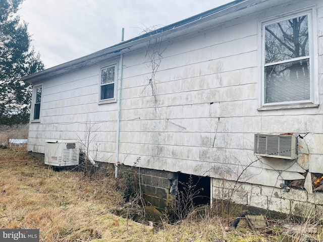 view of home's exterior with a wall mounted AC