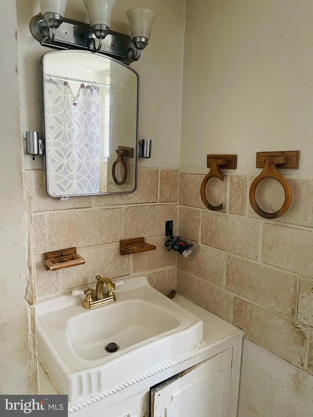 bathroom featuring vanity and tile walls