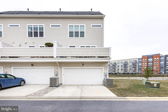 exterior space featuring central AC, concrete driveway, and an attached garage