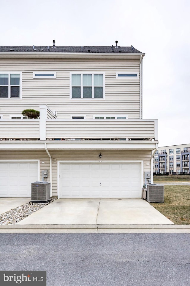 back of house featuring a garage, central air condition unit, and driveway