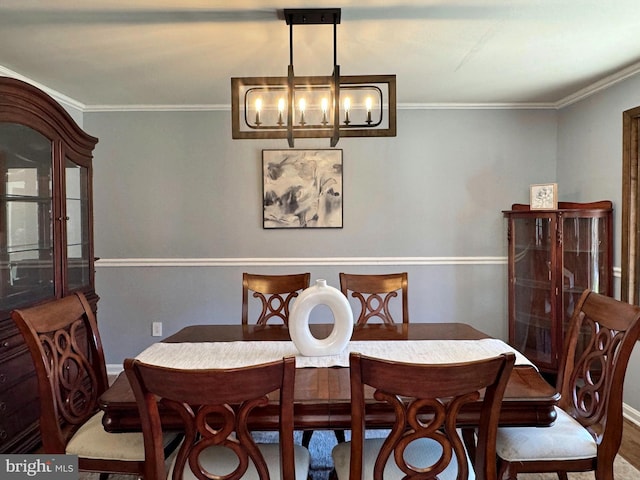 dining room with baseboards, an inviting chandelier, and ornamental molding