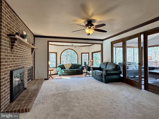 living room with dark colored carpet, ceiling fan, a fireplace, and ornamental molding