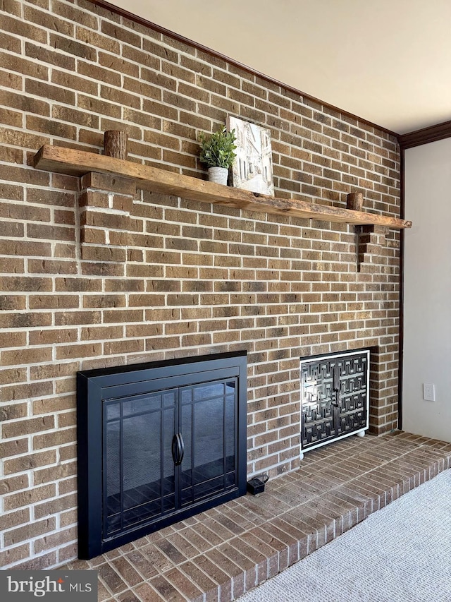 interior details featuring a brick fireplace and carpet