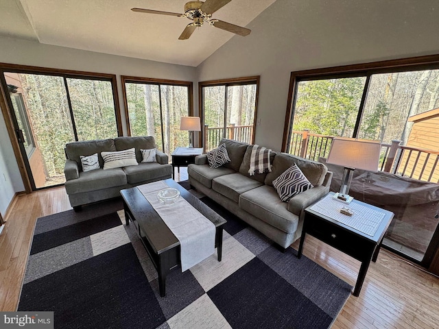 living area featuring high vaulted ceiling, light wood finished floors, and ceiling fan