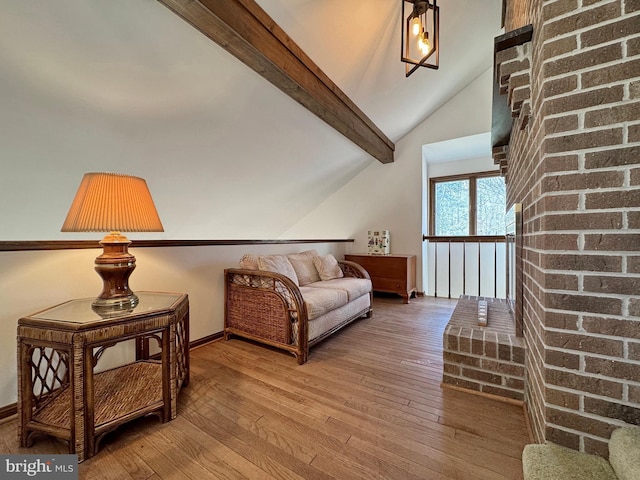 living area featuring hardwood / wood-style flooring and vaulted ceiling with beams