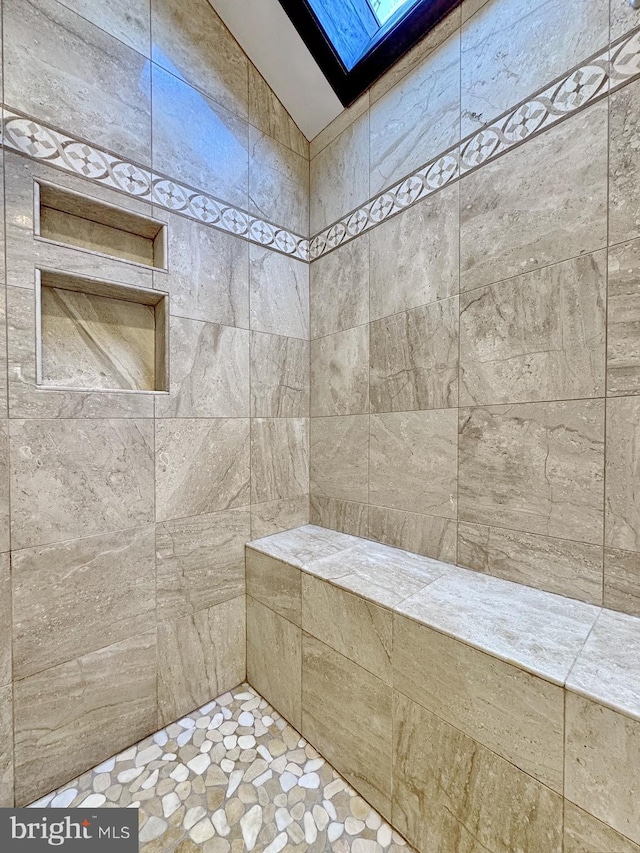 full bath with a skylight and tiled shower