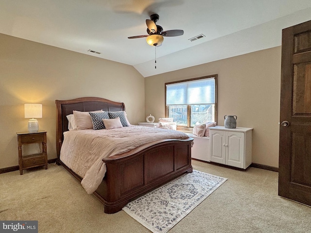 bedroom featuring visible vents, lofted ceiling, and light colored carpet