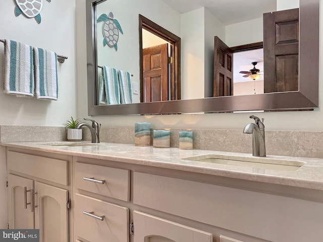 bathroom with ceiling fan, double vanity, and a sink