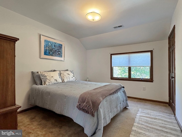 carpeted bedroom with lofted ceiling, baseboards, and visible vents