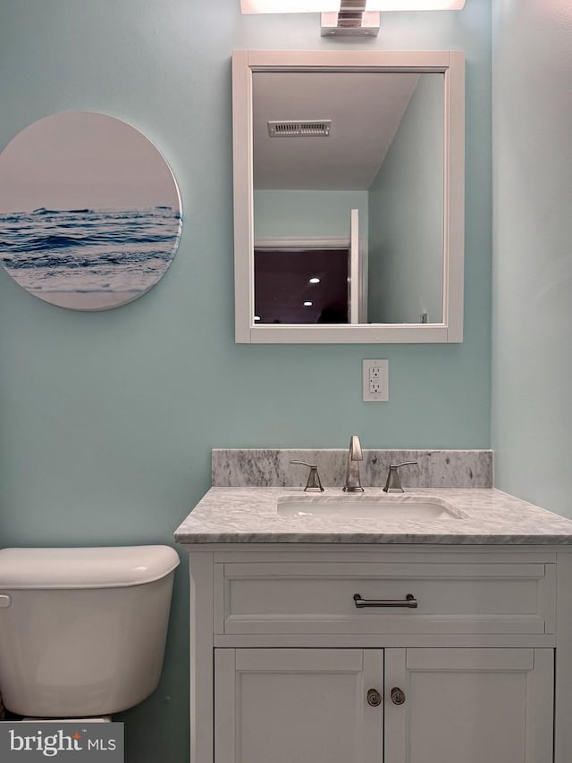 bathroom featuring visible vents, toilet, and vanity