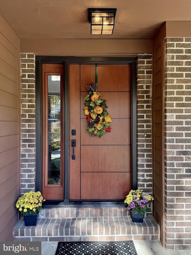 doorway to property featuring brick siding