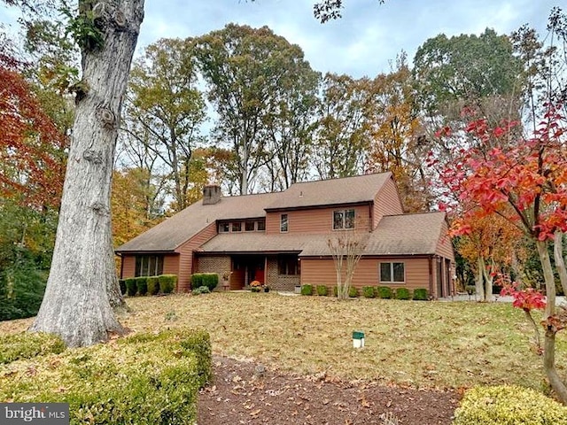 view of front of property featuring a front lawn and a chimney