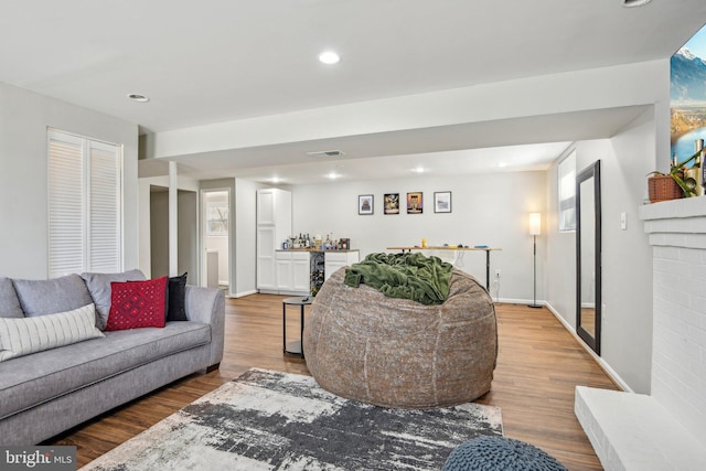 living room with visible vents, baseboards, a dry bar, recessed lighting, and wood finished floors