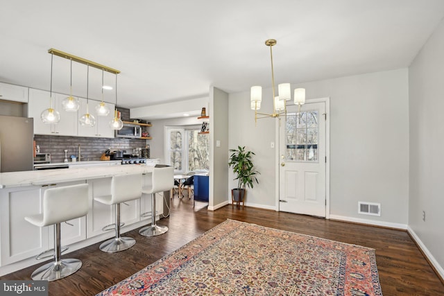 kitchen featuring visible vents, open shelves, decorative backsplash, appliances with stainless steel finishes, and dark wood-style flooring