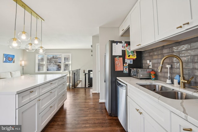 kitchen with dark wood-type flooring, a sink, stainless steel dishwasher, white cabinets, and decorative backsplash