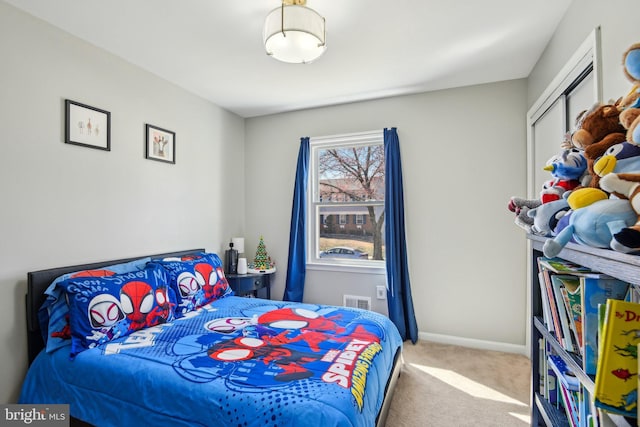 carpeted bedroom with visible vents, baseboards, and a closet