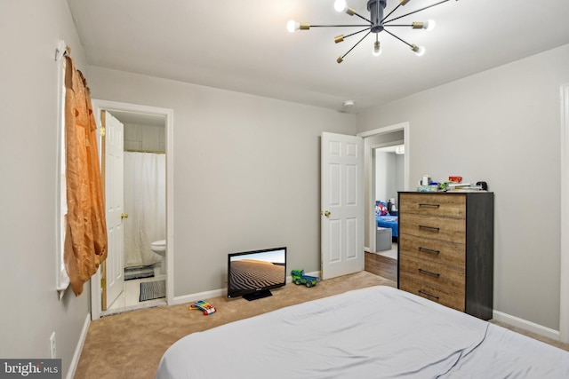 bedroom featuring a notable chandelier, carpet flooring, ensuite bath, and baseboards