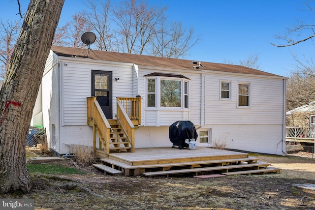 back of property with brick siding and a deck