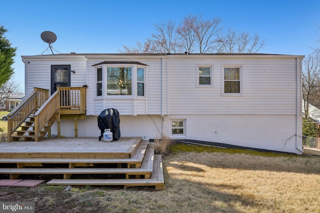 rear view of property with a wooden deck and a yard